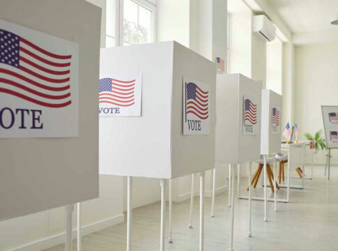 Voting booths with American flag signs.