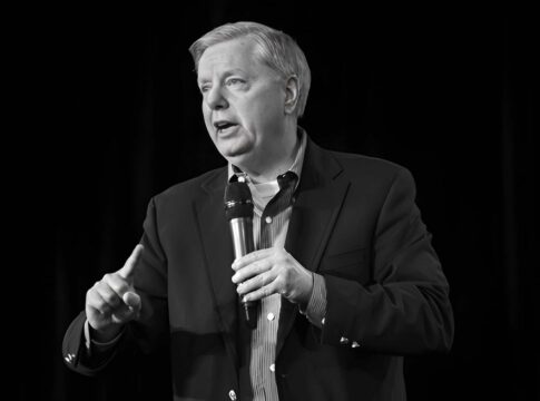 Man speaking into a microphone on stage