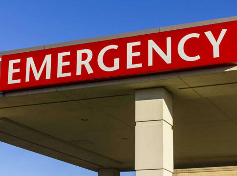Red and white Emergency sign outside building.