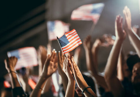 American flag held above a cheering crowd
