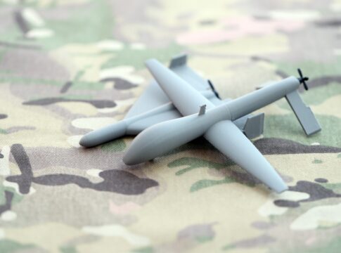 Small gray drone model on camouflage fabric